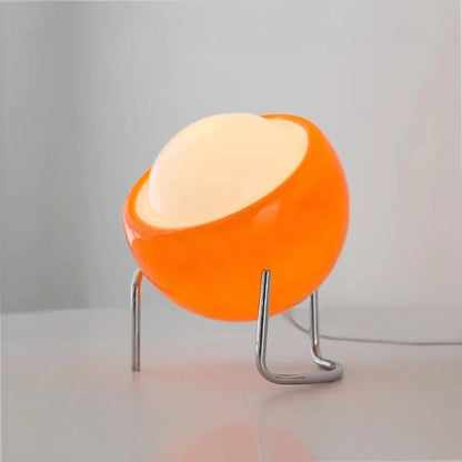 lampe en verre orange boule oeuf table blanche allumée